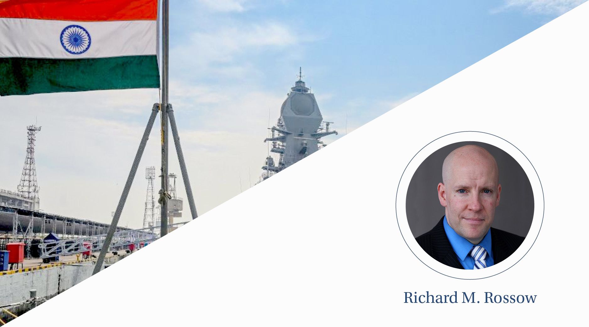 The Indian flag waves in front of a naval ship.