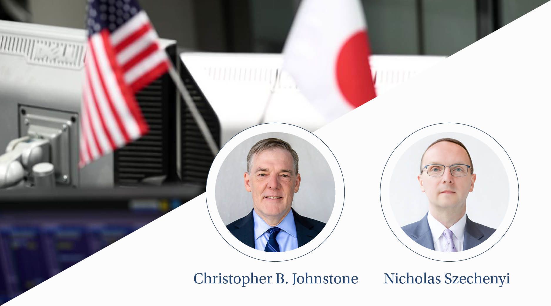 A man hides behind large monitors with miniature American and Japanese flags attached to it. 