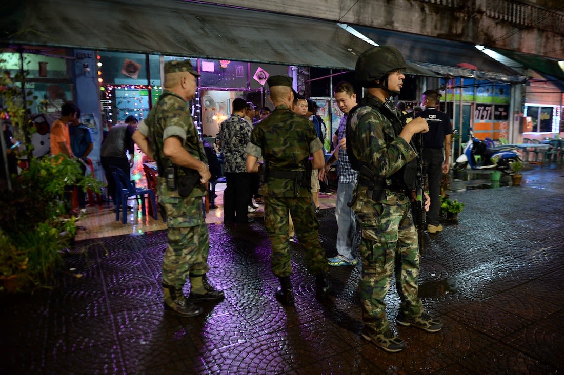 A group of Thai police standing outside at night.