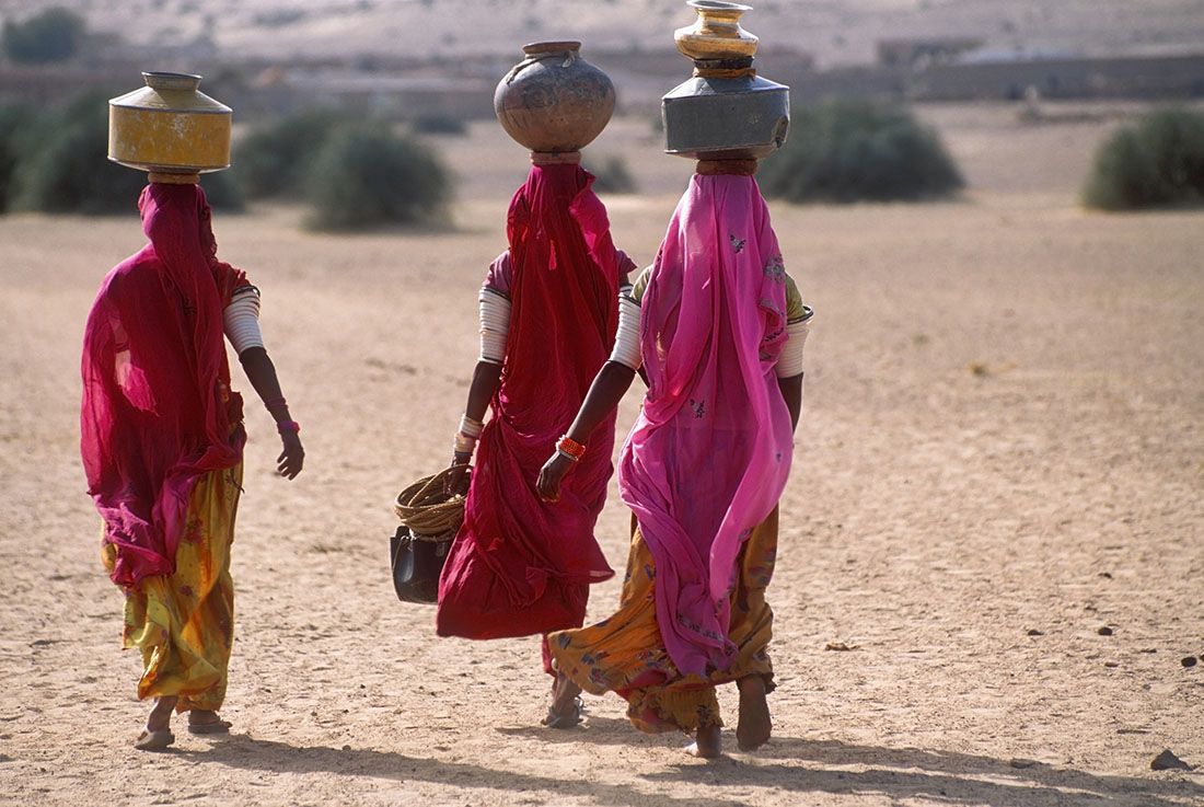 Women carry water in jars on their heads in Thar Desert, Rajasthan, India | Franz Aberham / Photodisc