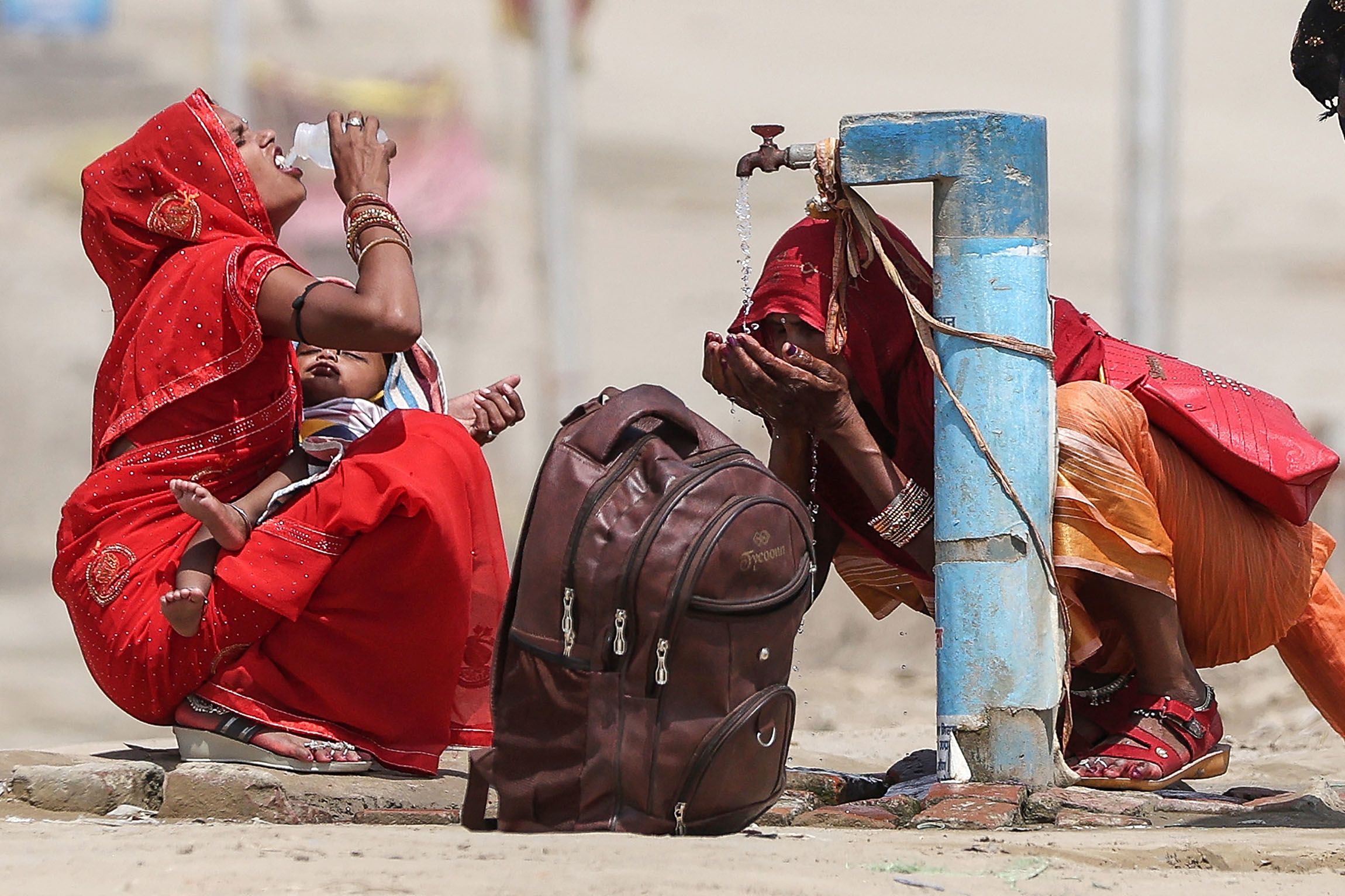 Women quench their thirst during a heatwave in Prayagraj, India in June 2024. | Anil Shakya/AFP via Getty Images