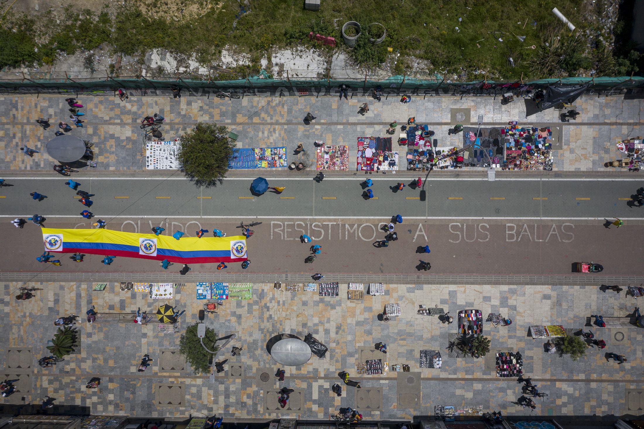 Aerial view of a message written on the street that reads 'we resist their bullets' as demonstrators gather with a Colombian flag as part of a protest as part of a national strike on May 19, 2021 in Bogota, Colombia.