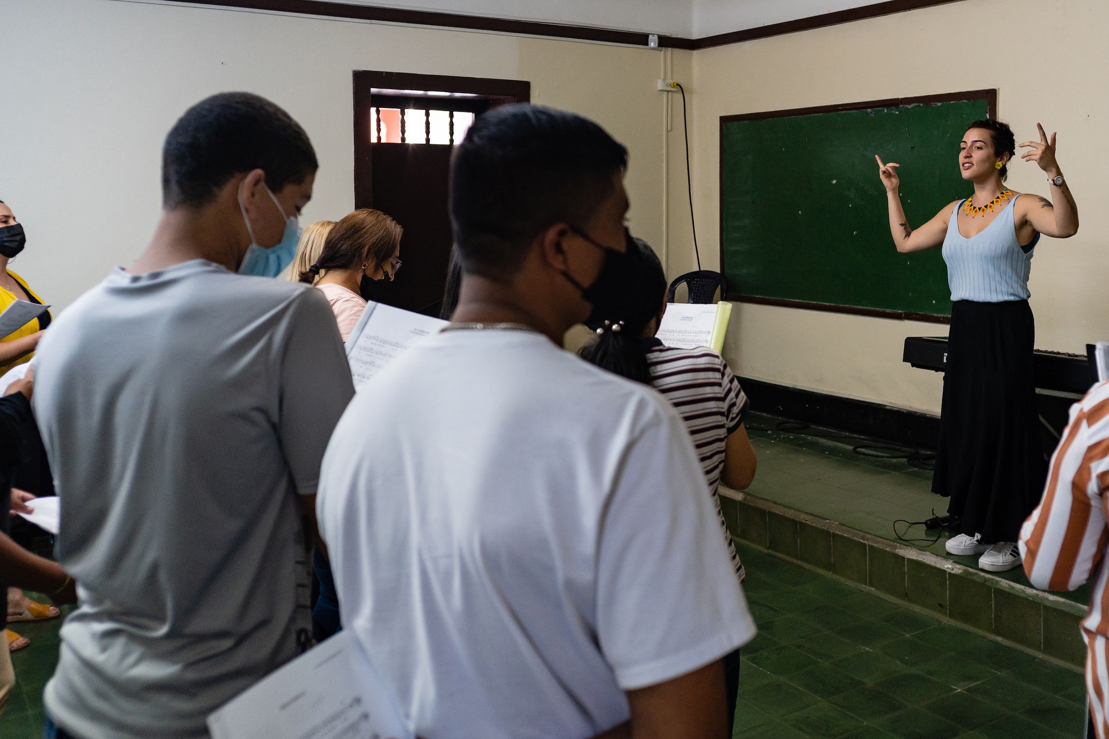 The teacher of the Reconciliation Choir, Marcela Correa, instructs her students with vocal techniques to improve the beauty of their voice, in Medellin, Colombia on April 02, 2022.