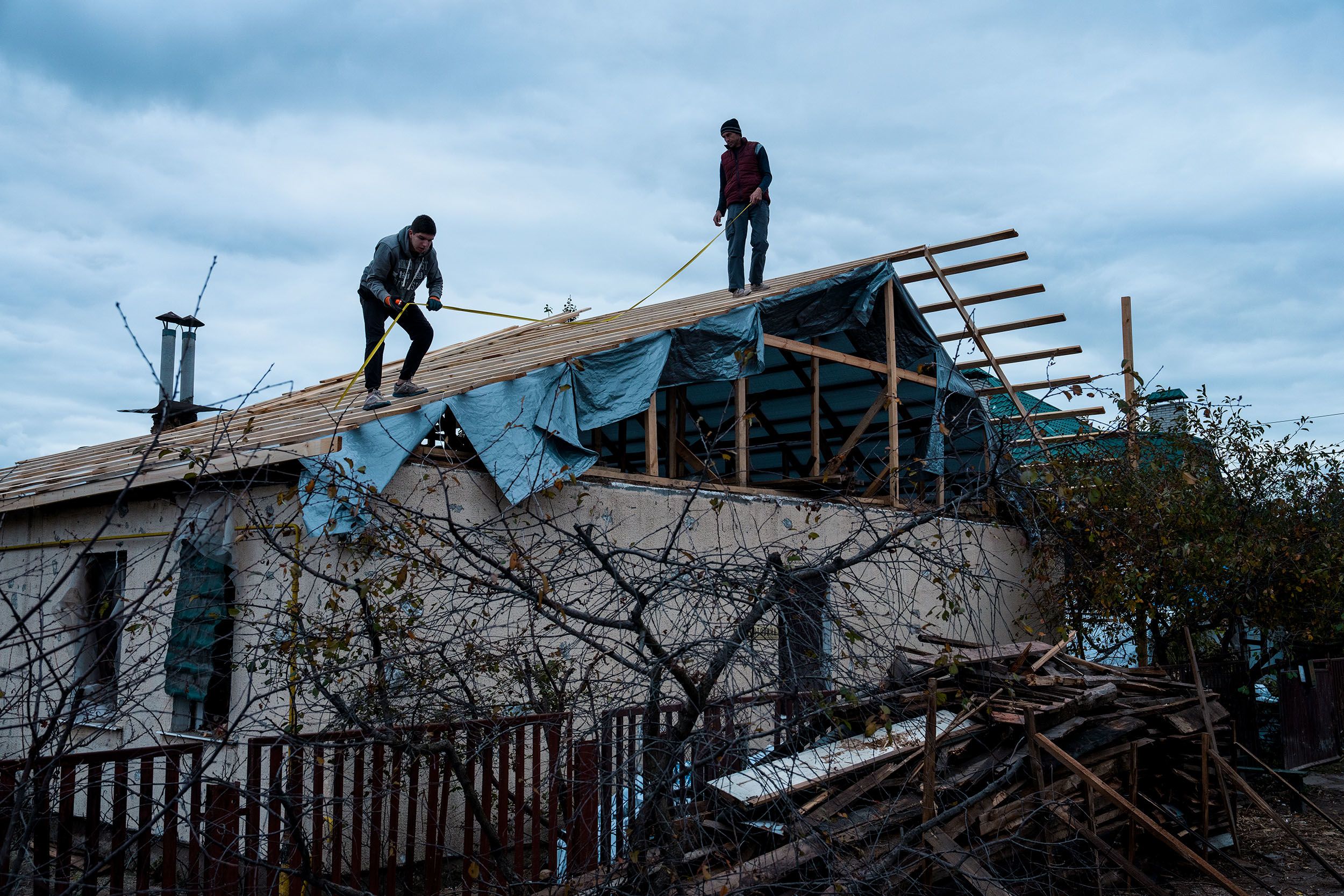 People work to rebuild a house after it was heavily damaged by a Russian missile attack