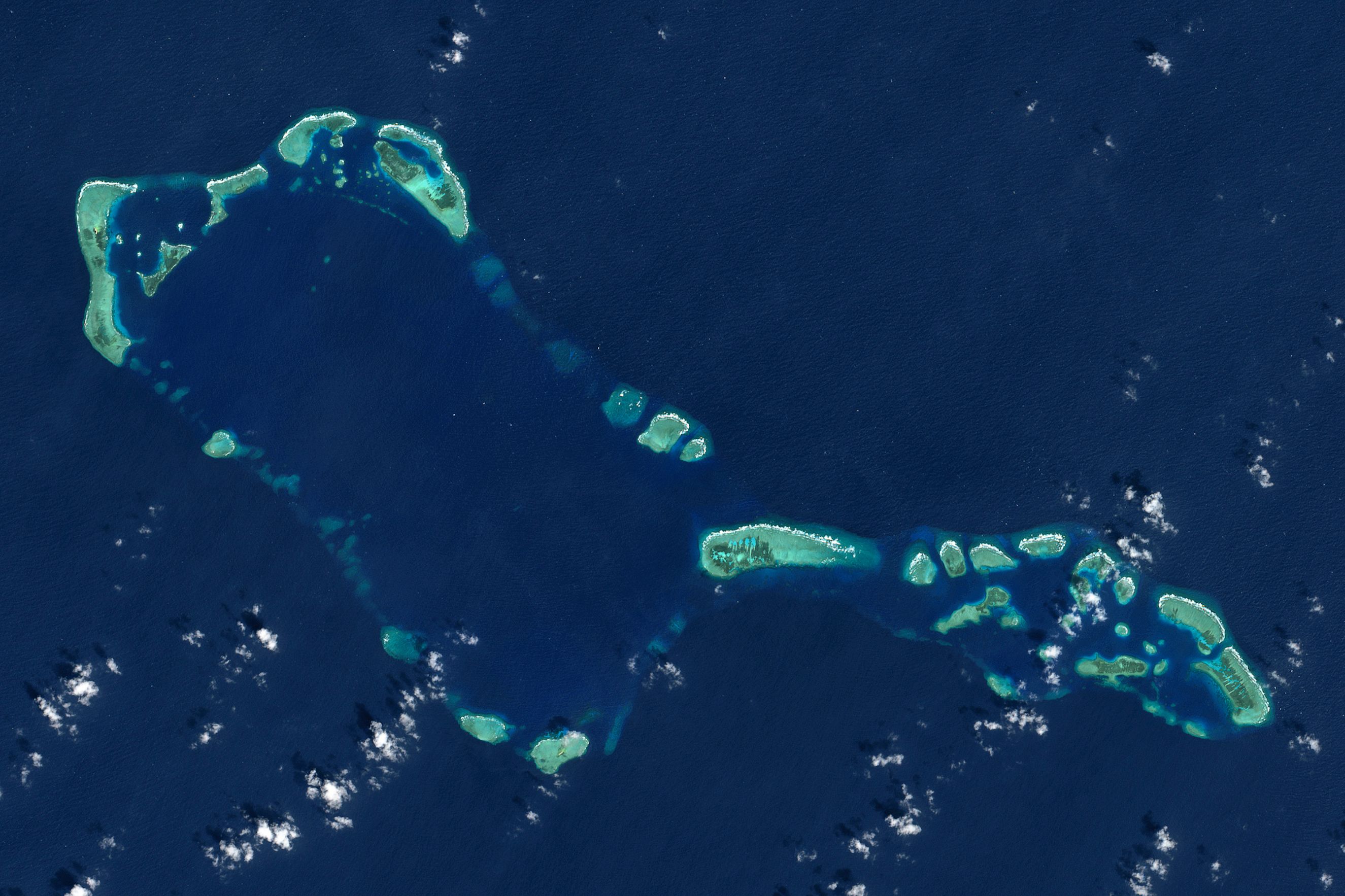 Satellite imagery of Sabina Shoal, an atoll forming a rectangular ring in the deep blue South China Sea.