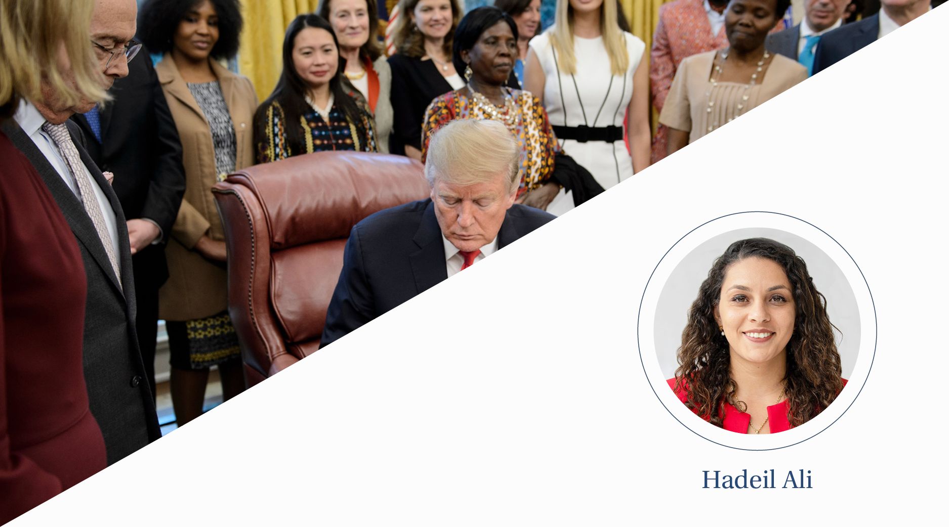 Donald Trump signs a document while a group of women look on.