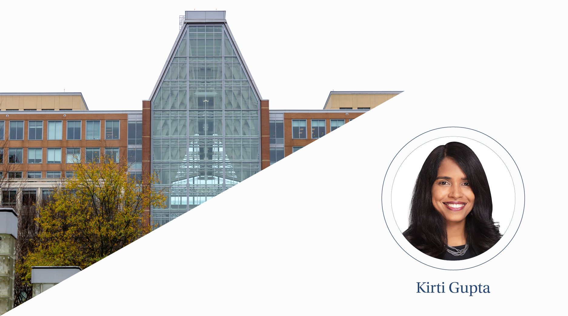 A view of a symmetrical glass building on a cloudy day.