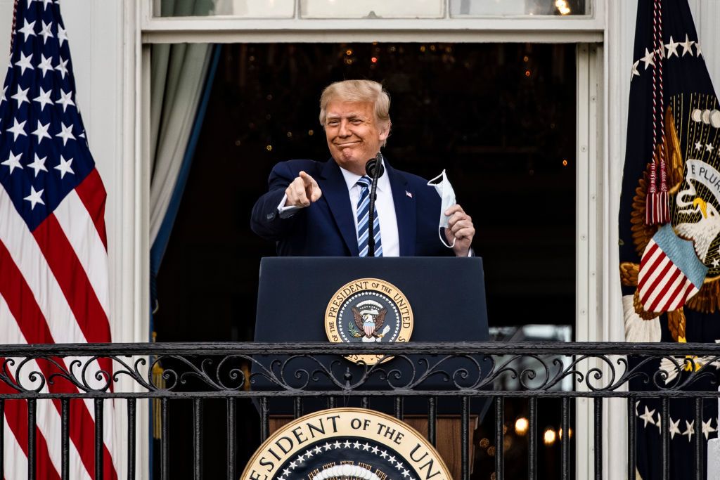 President Trump points towards the audience as he stands in front of a podium.