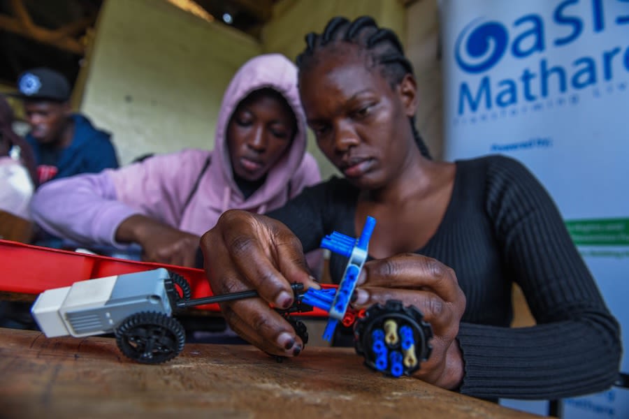 Teenagers work on a small lego device.