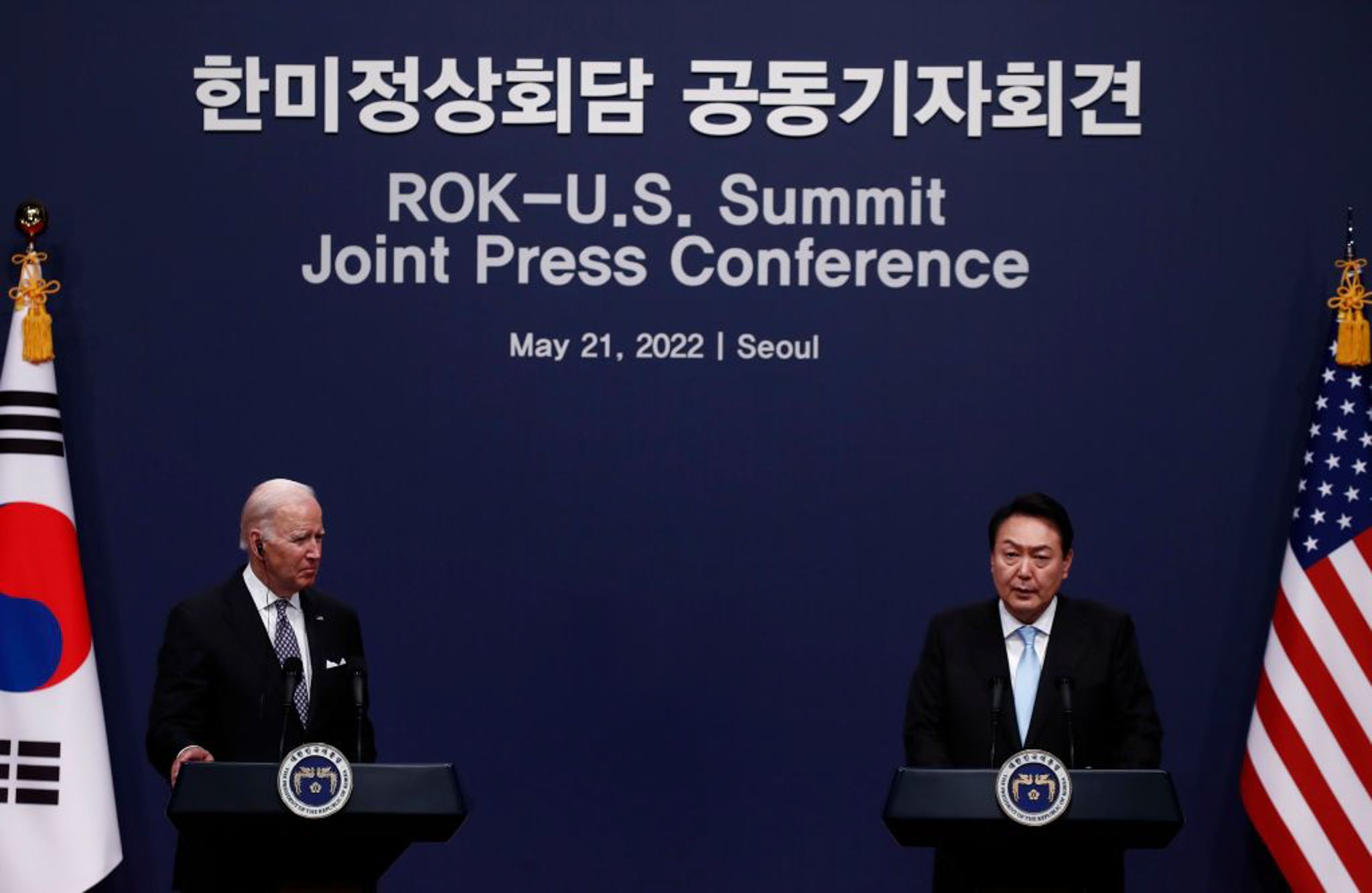 US President Joe Biden and South Korean President Yoon Suk Yeol stand at podiums during a press conference at a summit.
