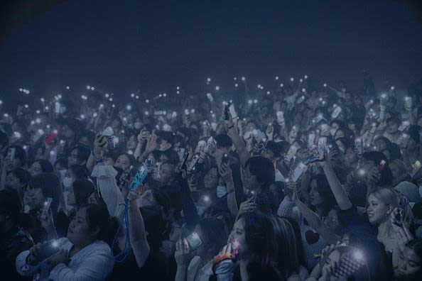 People in Bangkok hold up flashlights on their mobile phones during a concert. | Matt Hunt/SOPA Images/LightRocket via Getty Images