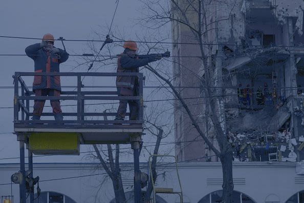 Energy and utility workers operating to restore power and heat supply after a Russian drone strike on a residential area on December 27, 2025 in Kyiv, Ukraine. | Yevhenii Zavhorodnii/Global Images Ukraine via Getty Images.