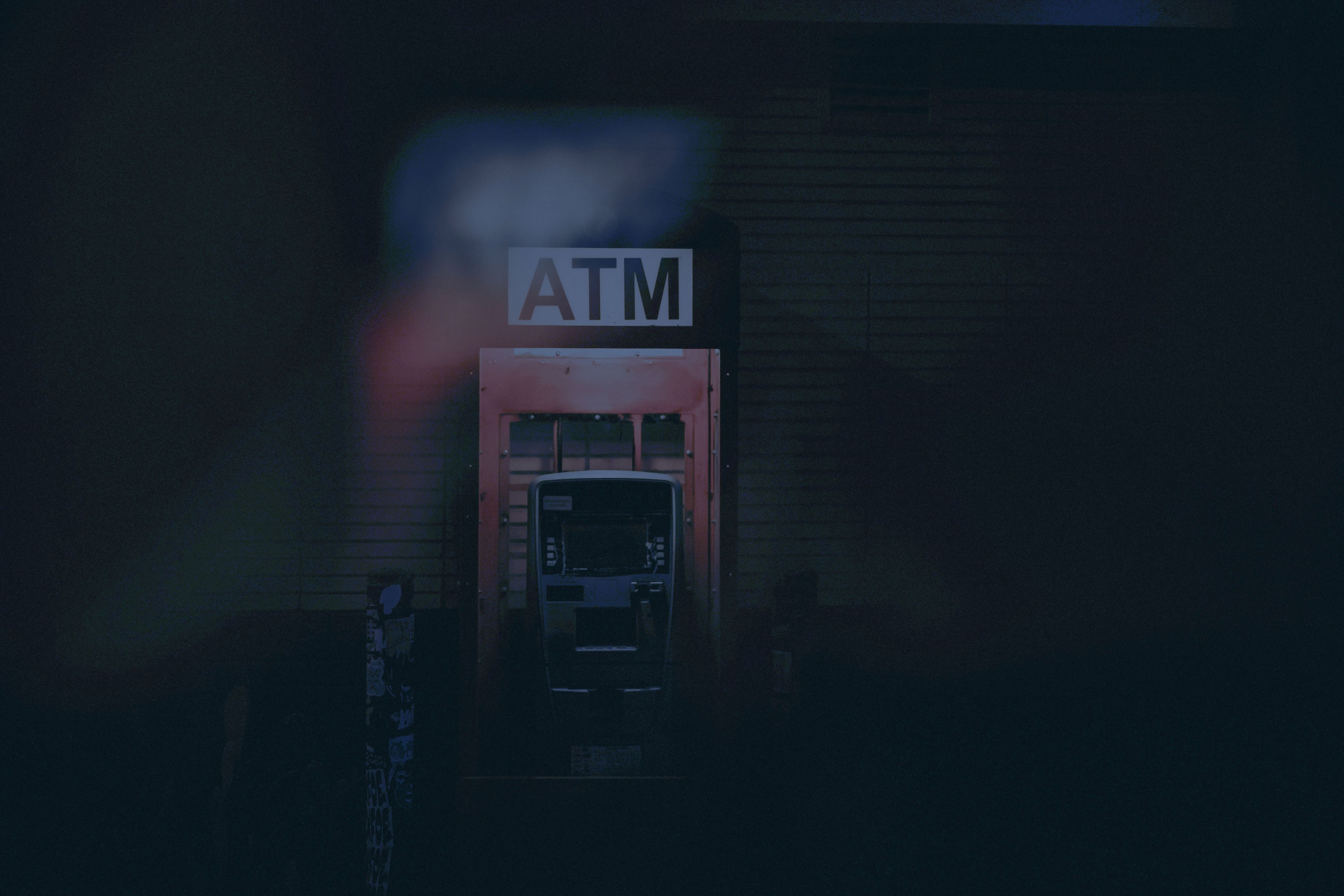 a building with a atm sign lit up at night | Photo by Jake Allen on Unsplash