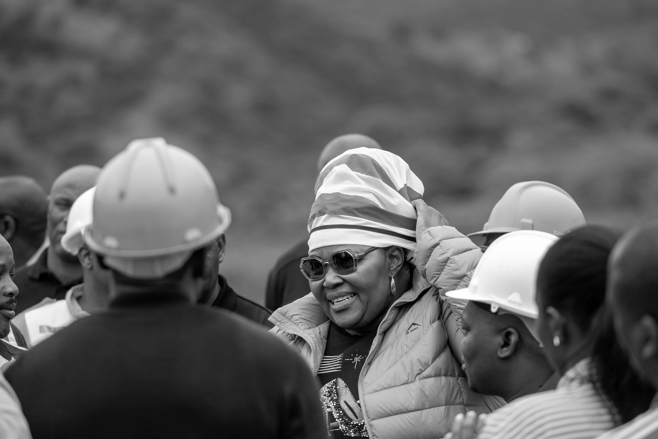 A woman washes clothes using a small basin of water.