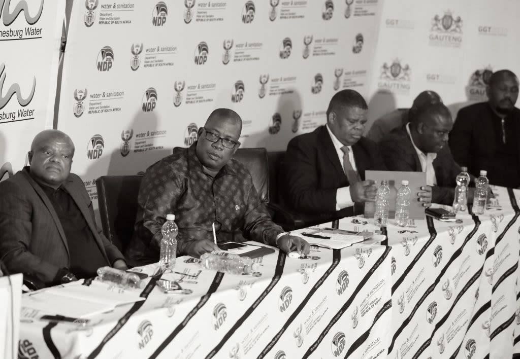 a foggy street with several buses parked on the side of the road