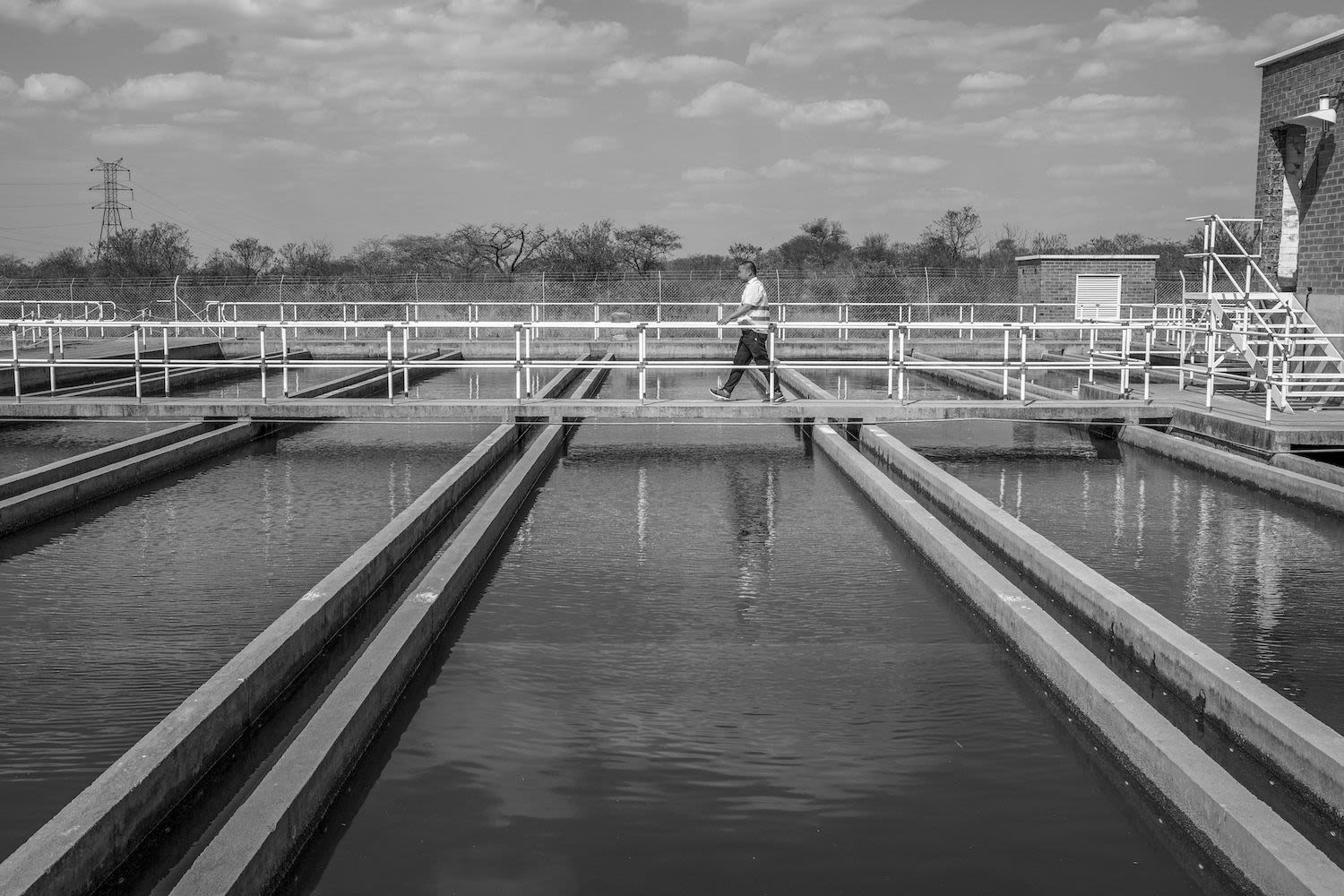 A woman washes clothes using a small basin of water.