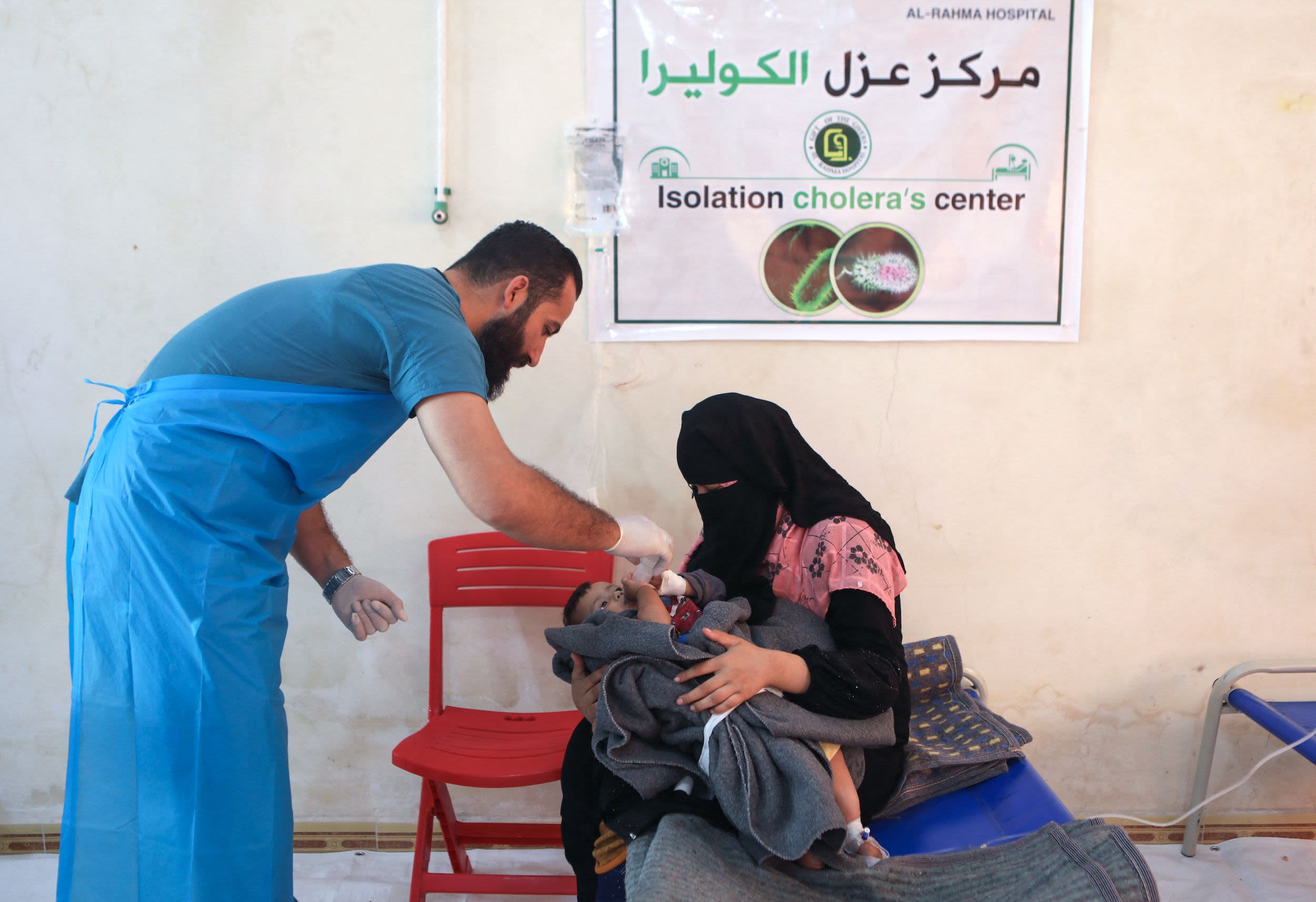 A medic treats a baby brought by his mother at a recently-opened medical center for Cholera cases in the Syrian town of Darkush, on the outskirts of the rebel-held northwestern province of Idlib, on October 22, 2022. - The disease is making its first major comeback since 2009 in Syria, where nearly two-thirds of water treatment plants, half of pumping stations and one-third of water towers have been damaged by more than a decade of war, according to the United Nations. (Photo by Aaref WATAD / AFP) 