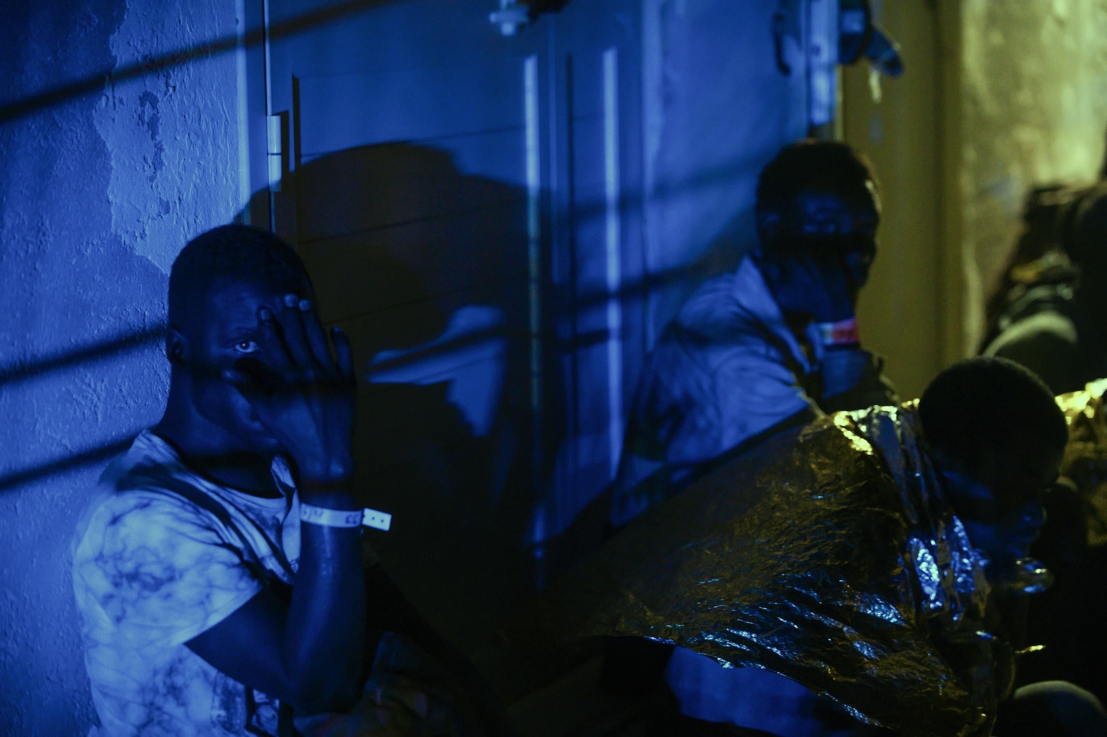 Migrants wait for the transfer on Italy's Lampedusa Island, which is overwhelmed after more than 100 migrant boats arrived according to the Italian Red Cross. | Valeria Ferraro/Anadolu Agency via Getty Images