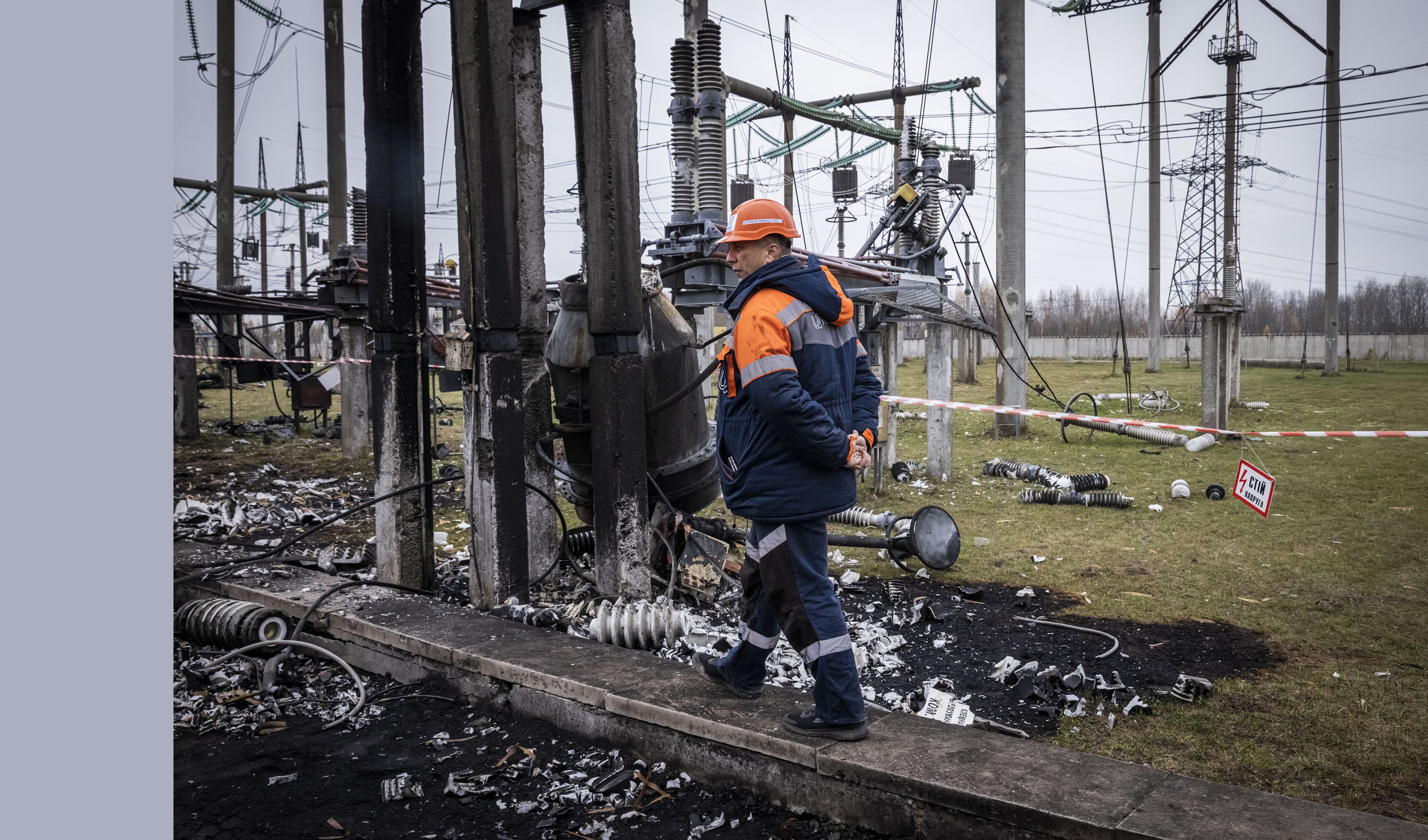 A worker walks by a damaged power substation